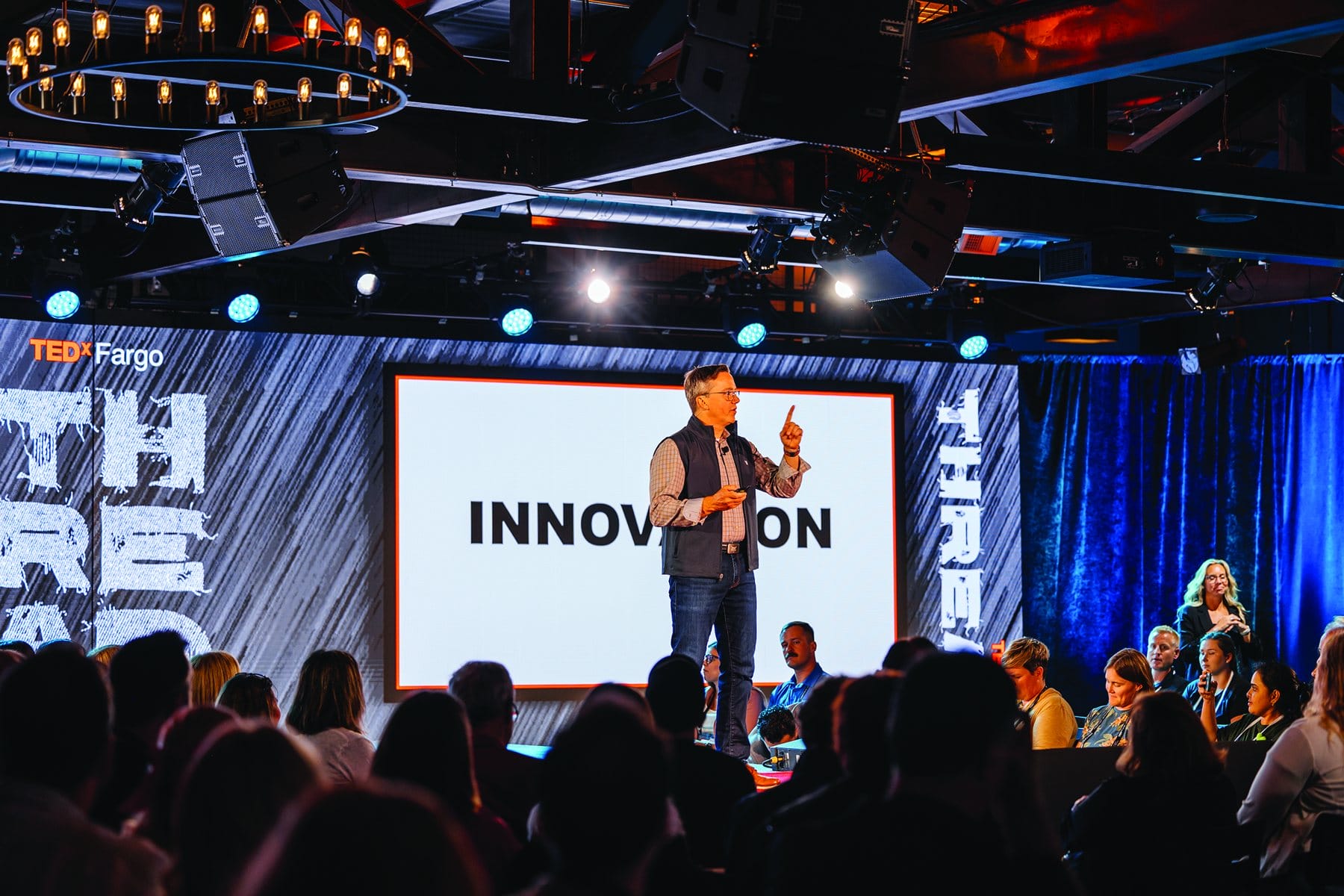 Speaker on a lit stage at an event